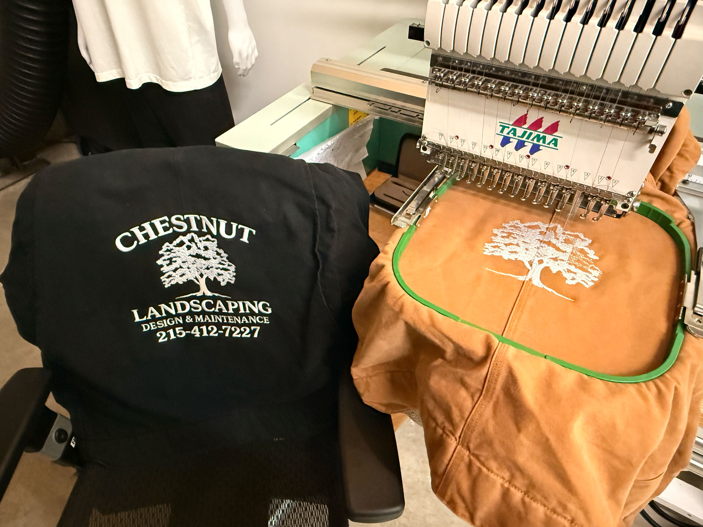 Embroidery machine stitching tree logo on hoodie